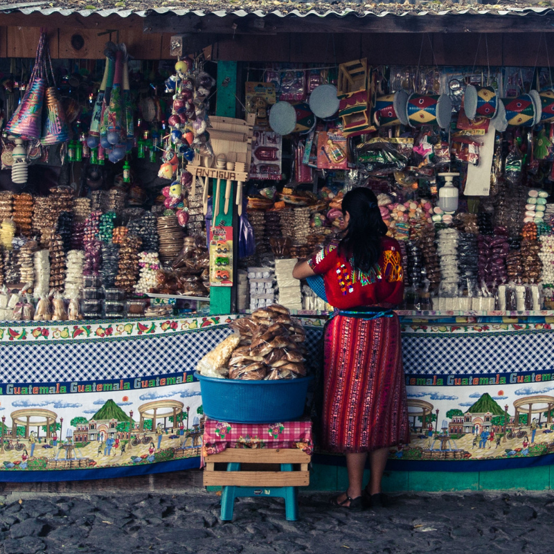 Woman in Guatemala standing in front of a candy stand