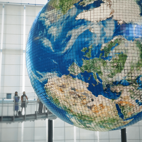 Two women looking at a model of Earth.