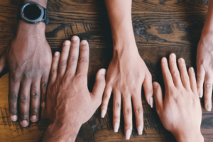 Hands Five hands next to each other on a table.