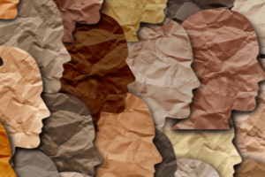19 side profiles of human faces are overlapping each other. They are cut out of different colored paper.