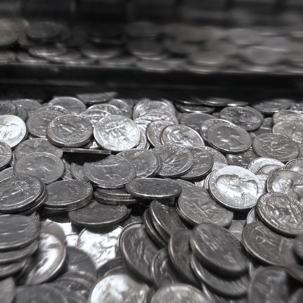 Hundreds of silver US quarter dollars in a pile.