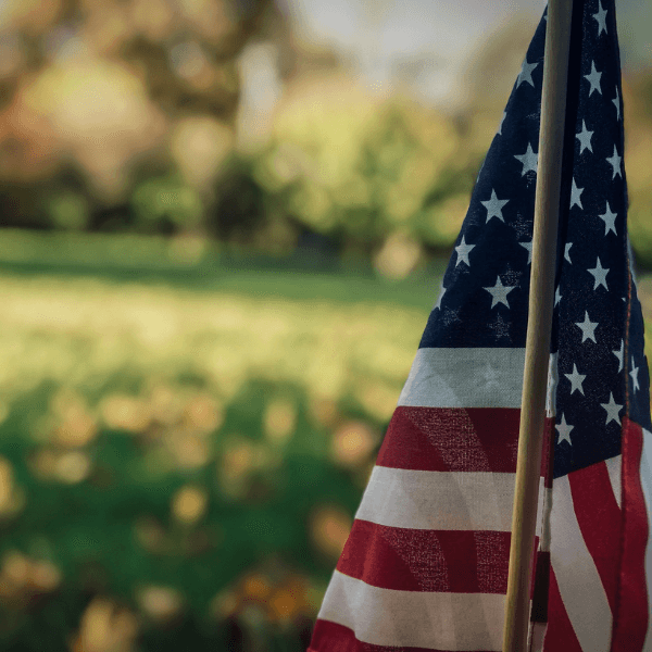 An American Flag is sat on a field of grass.