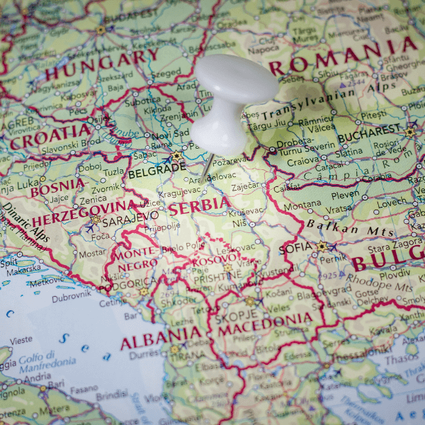 A close up image of a map of Serbia with a white push-pin next to the text "Serbia."