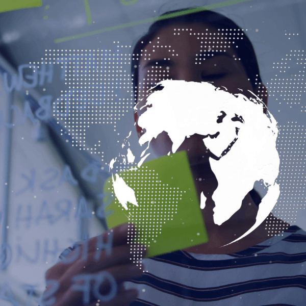 A POV from behind a screen of a woman looking at an outline of a map of the Earth.