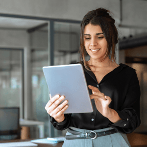 A front-on view of a woman looking at and using an iPad.